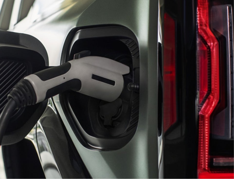 Close up of charging port with charger plugged in on a GMC Hummer EV SUV - McCarthy Auto World in Coon Rapids MN